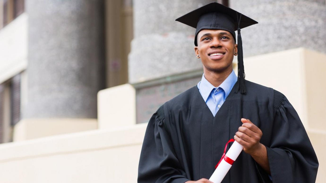 Happy graduate holding their diploma