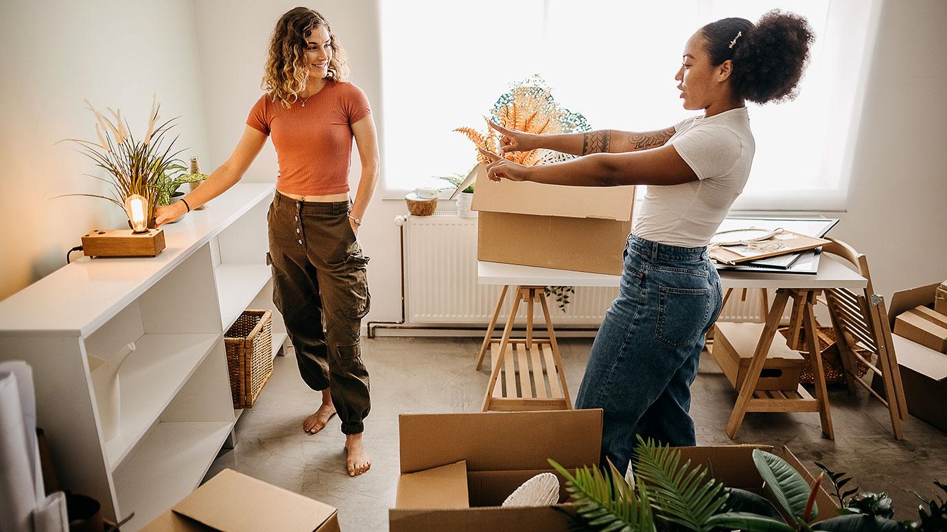 Two girls are furnishing their new apartment together