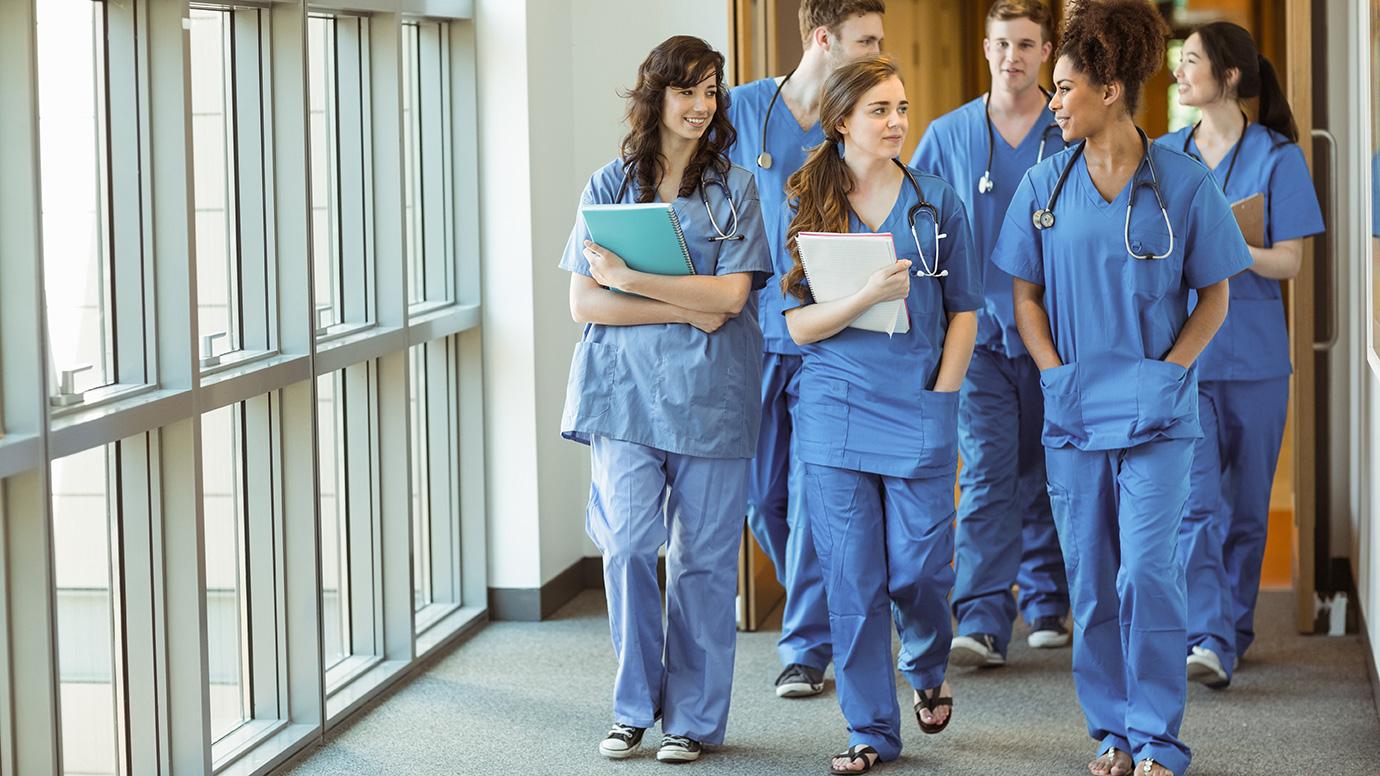 A group of medical students walking together through a corridor