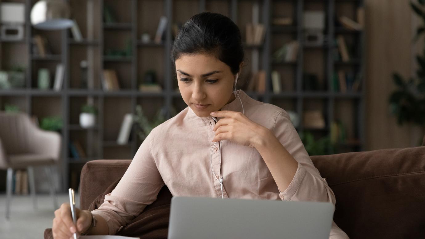 Student behind her laptop taking notes
