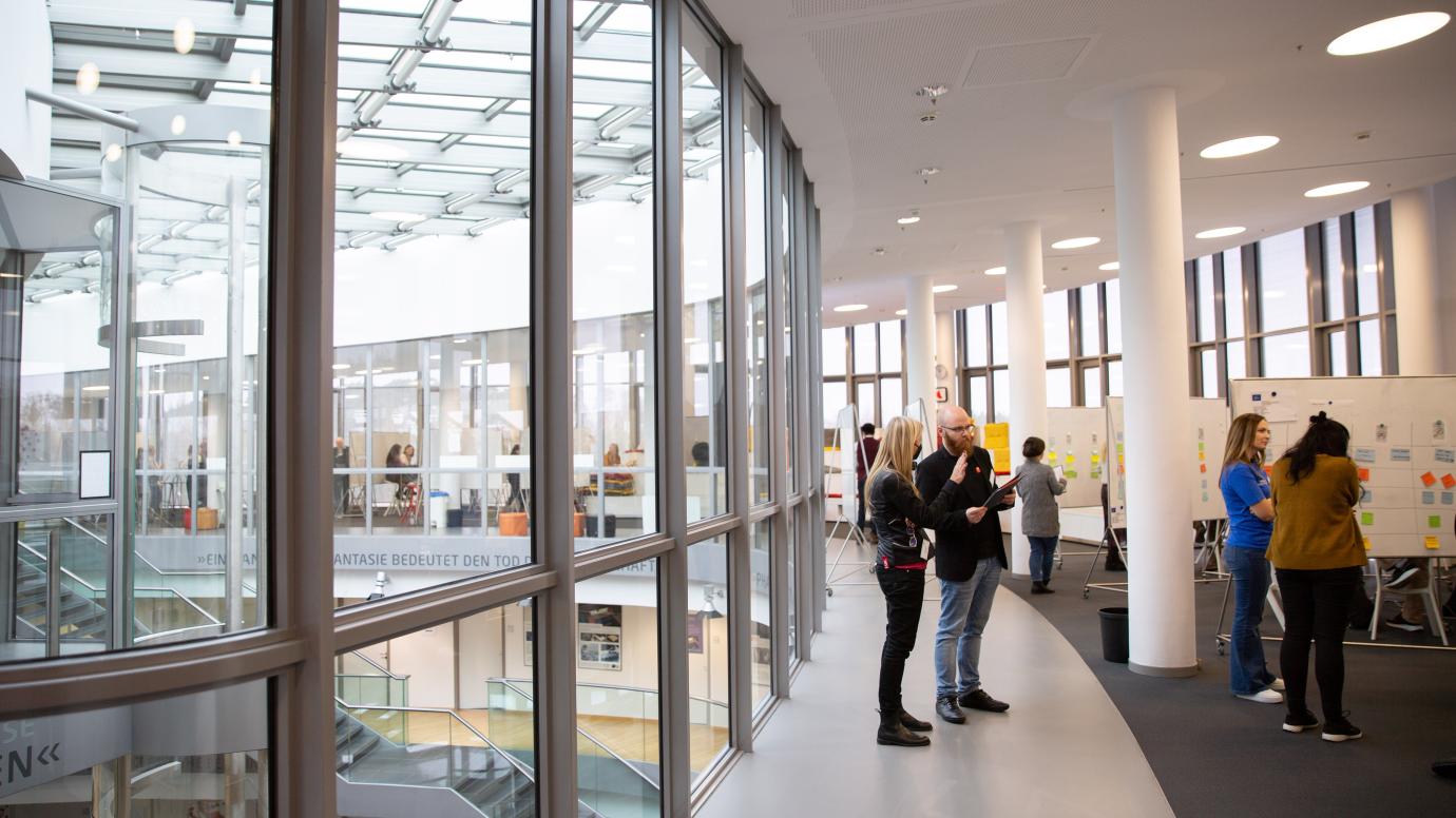 Small groups of people discussing in a large conference centre hall