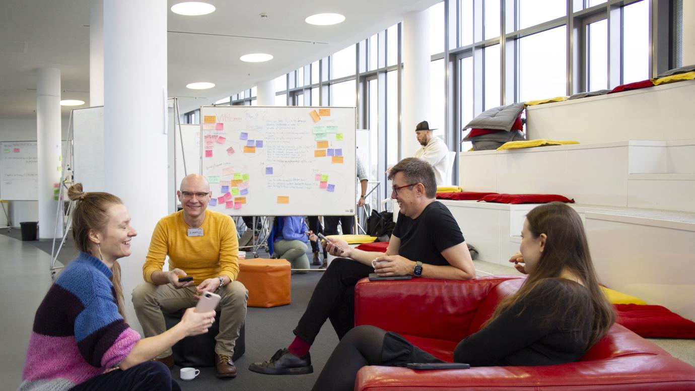 Group of 4 people seating in armchairs and discussing during a workshop