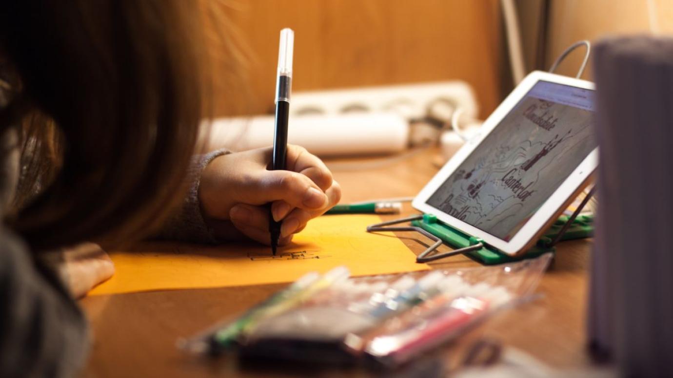A young woman drawing from an image on a tablet