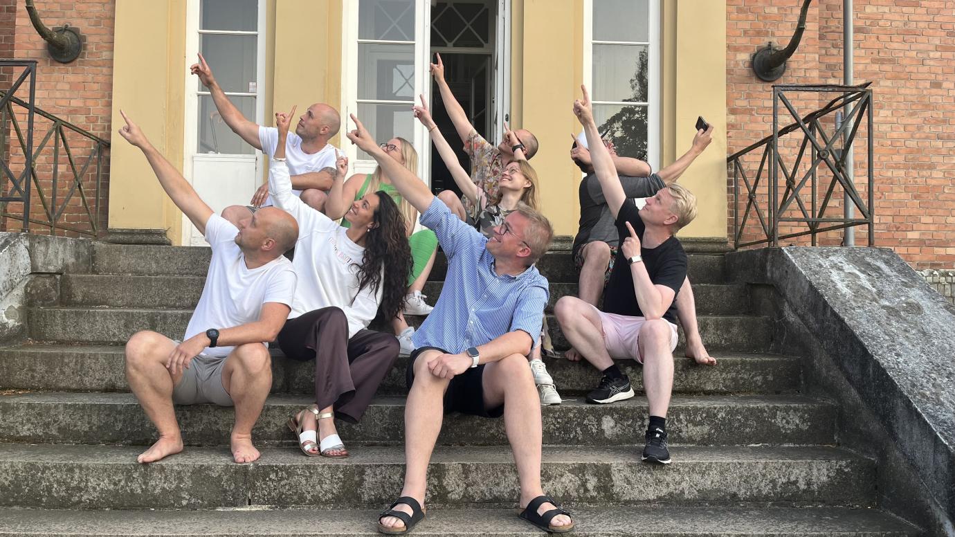 Group of people pointing towards upper left