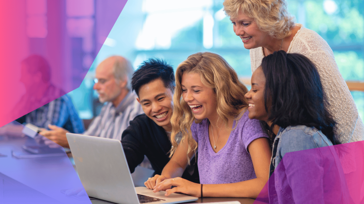 Diverse team of cheerful students and teacher in front of a laptop