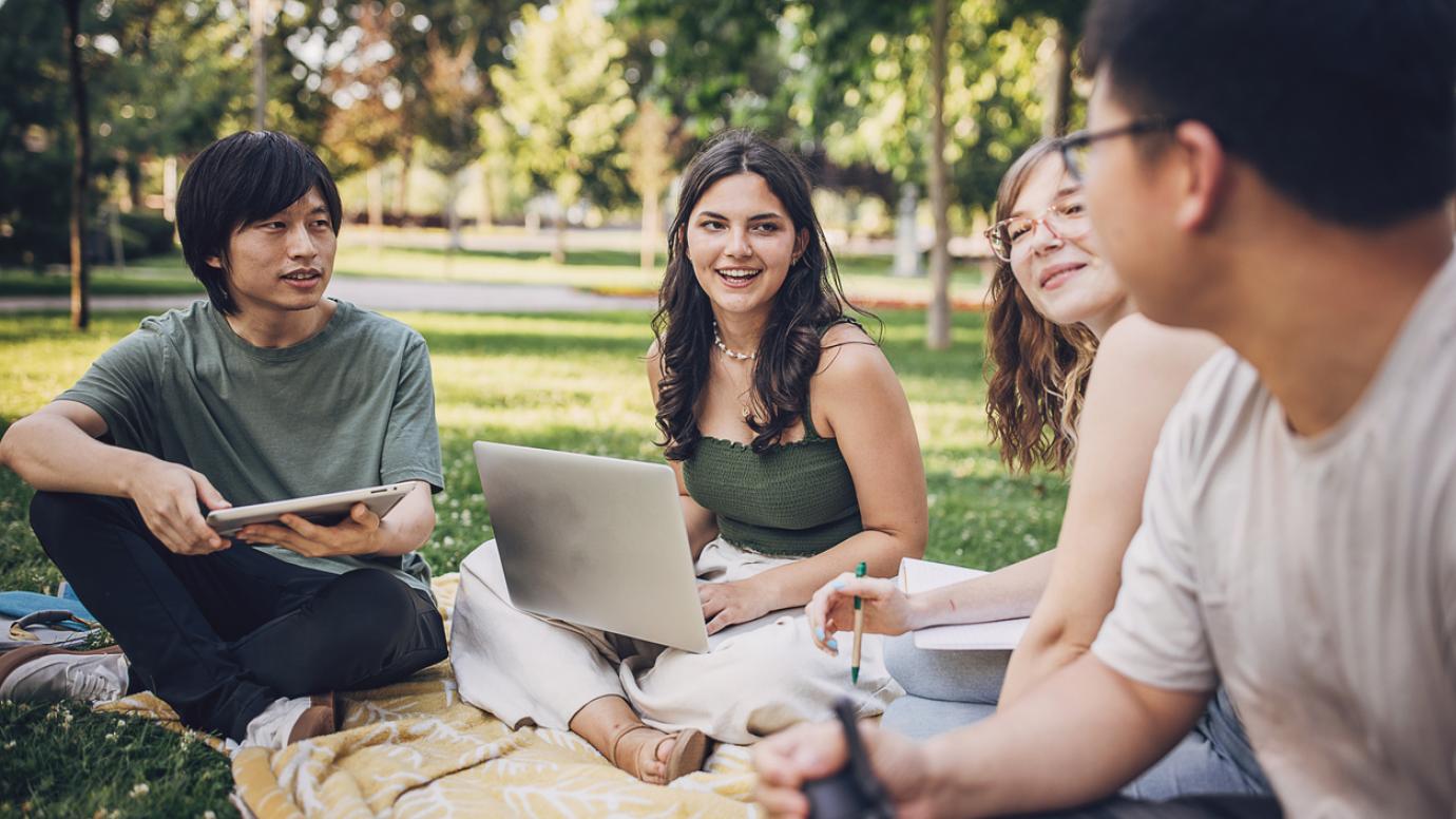 Group of young diverse students studying in a park