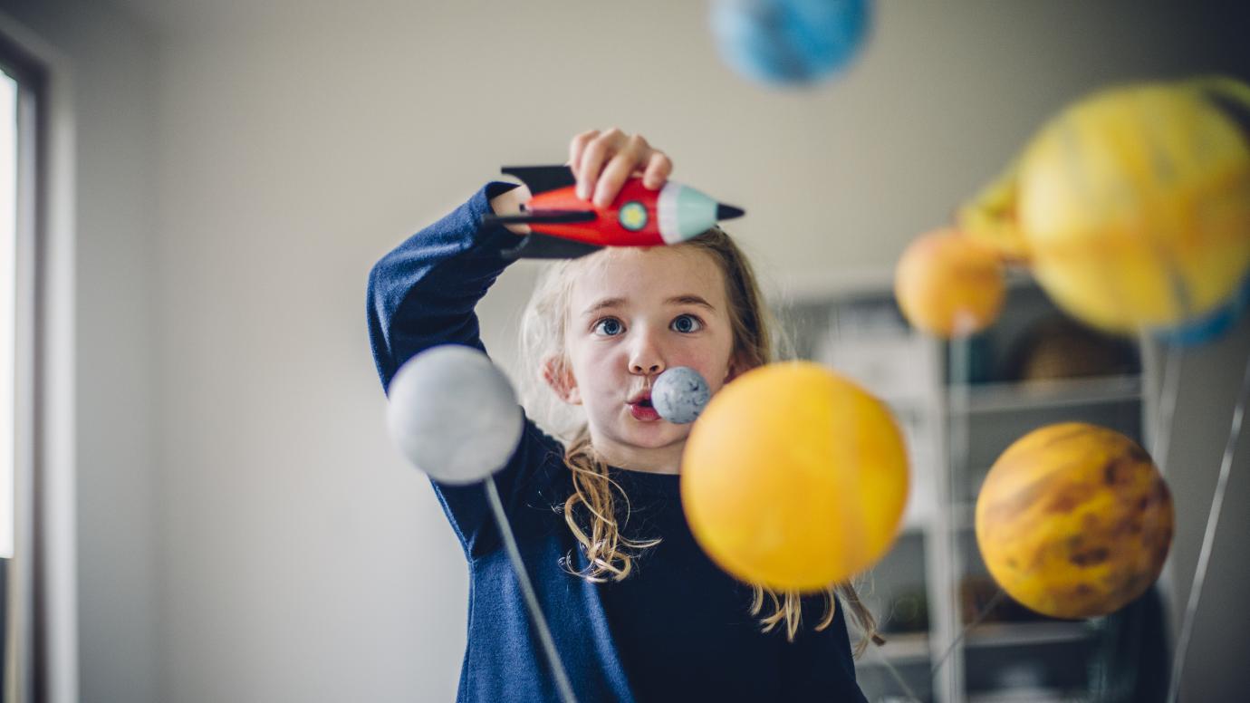 Young girl playing with toy rocket