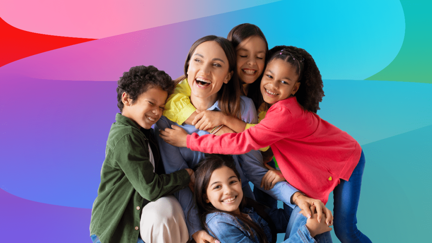 Young children giving female teacher a group hug